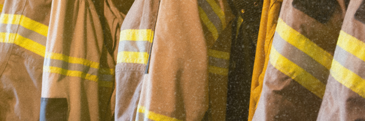 6 firefighters coats placed on a rack