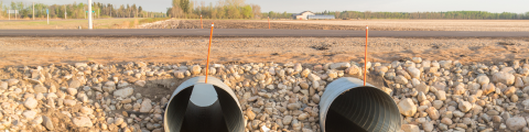 2 culvarts on a road with fields behind